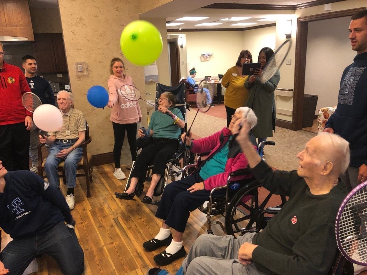 students visiting and having fun with residents in a nursing home