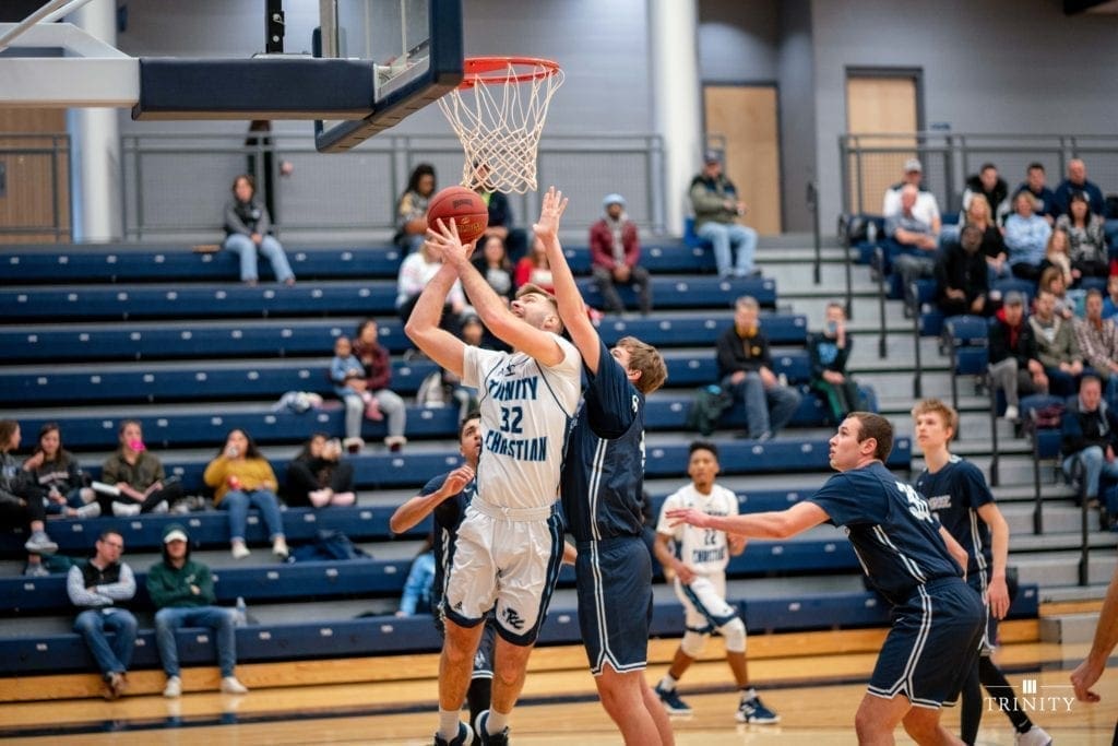 Men's basketball game: player driving to the hoop through contact