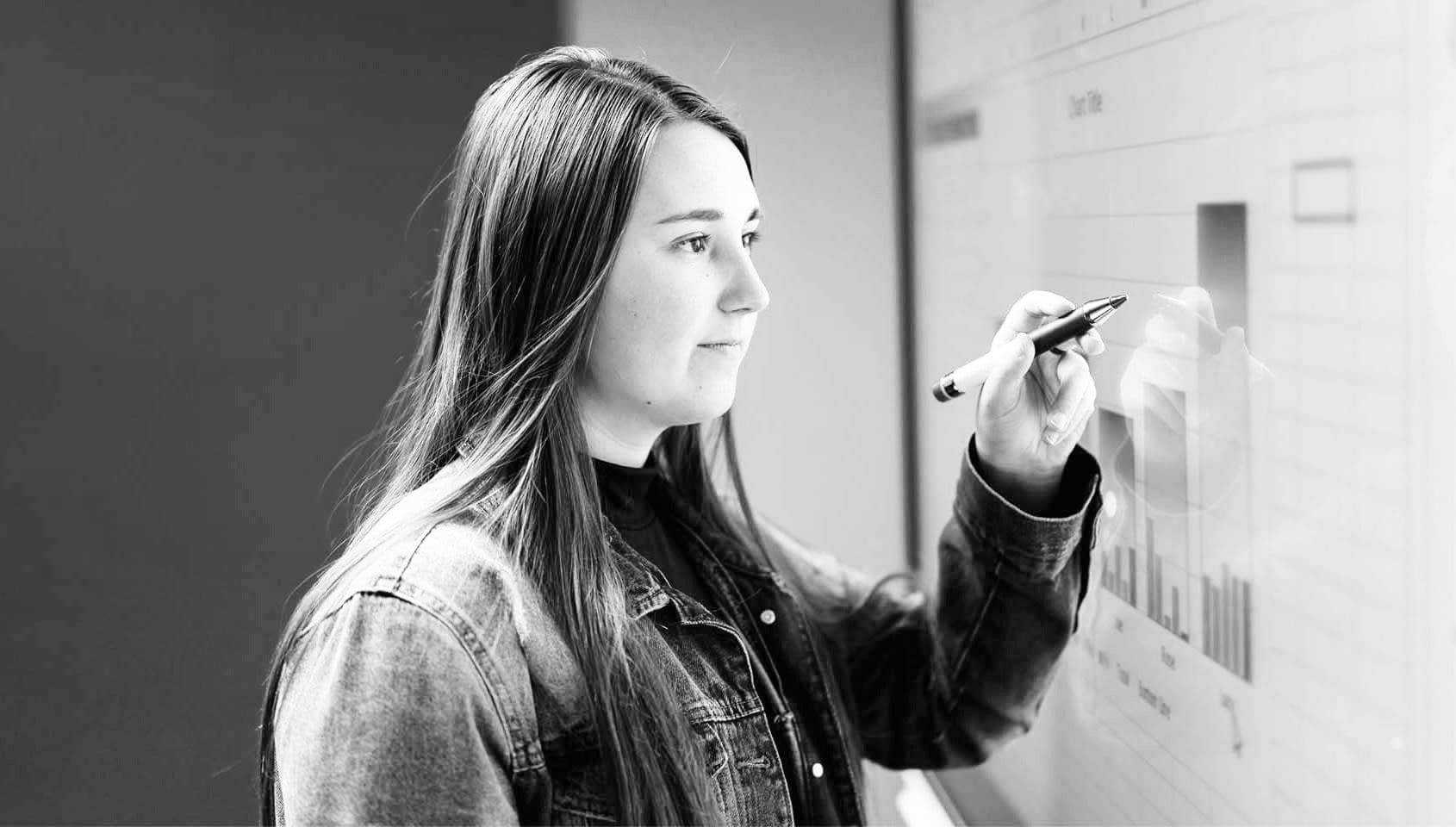 Data Analytics black and white picture of student writing on smart board