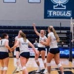 women's volleyball team celebrating on the court