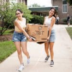 Move-In Day: students working together carrying a box outside south hall
