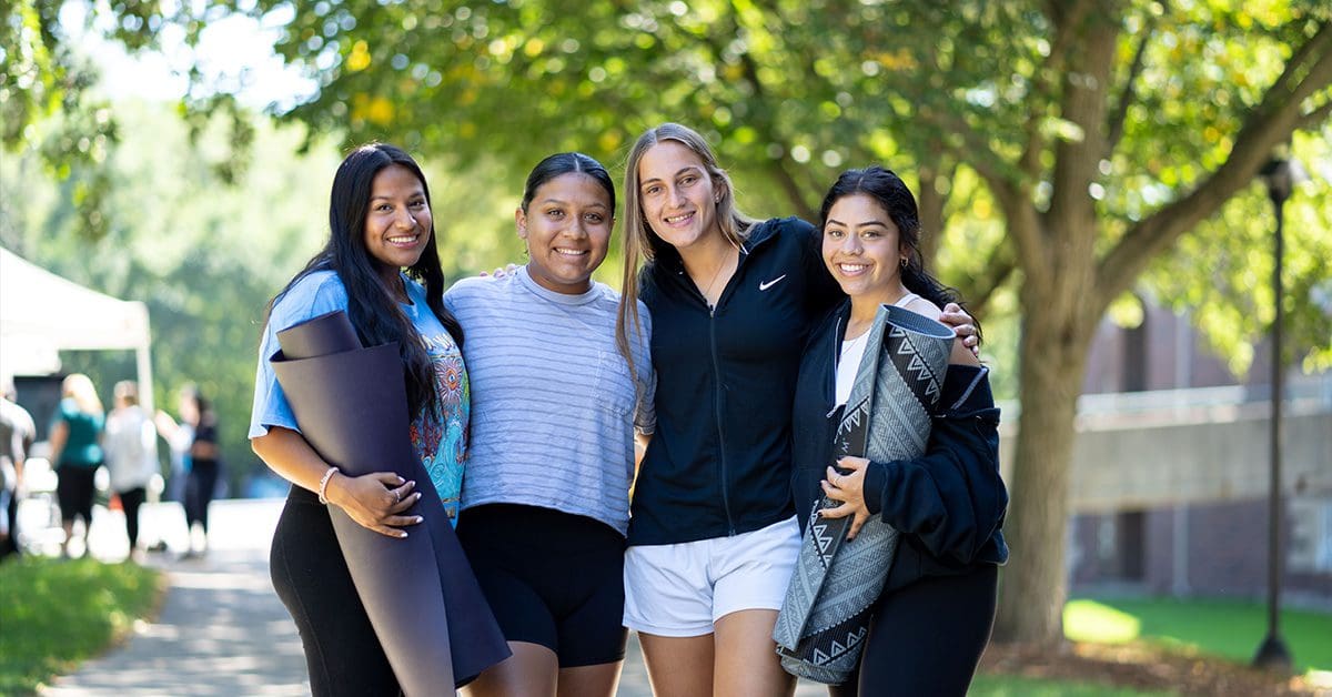 Students on campus with yoga mats