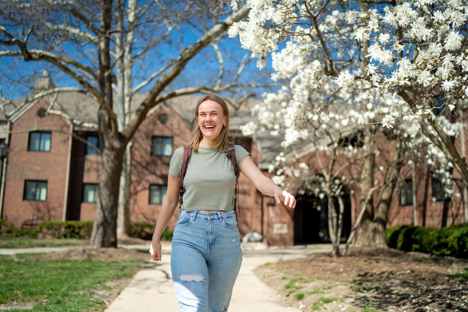 Student walking on a spring blooming campus